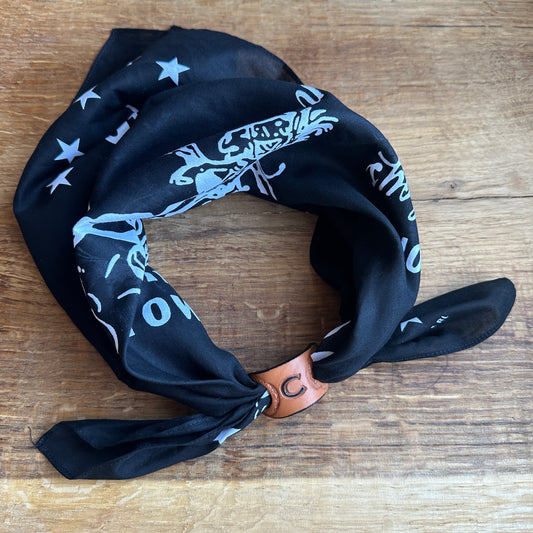 Personalisierbarer Tuchring aus Leder auf einem Holzuntergrund, ideal für Western-Stil und Biker-Outfits.