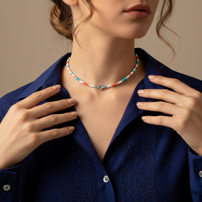 Schmale Perlenkette bunt Echt Silber mit Blumenperle, Türkis, Orange und Weiß, getragen von einer Frau.